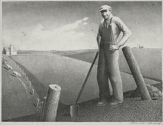 Man standing in a field with his arm resting on a hoe