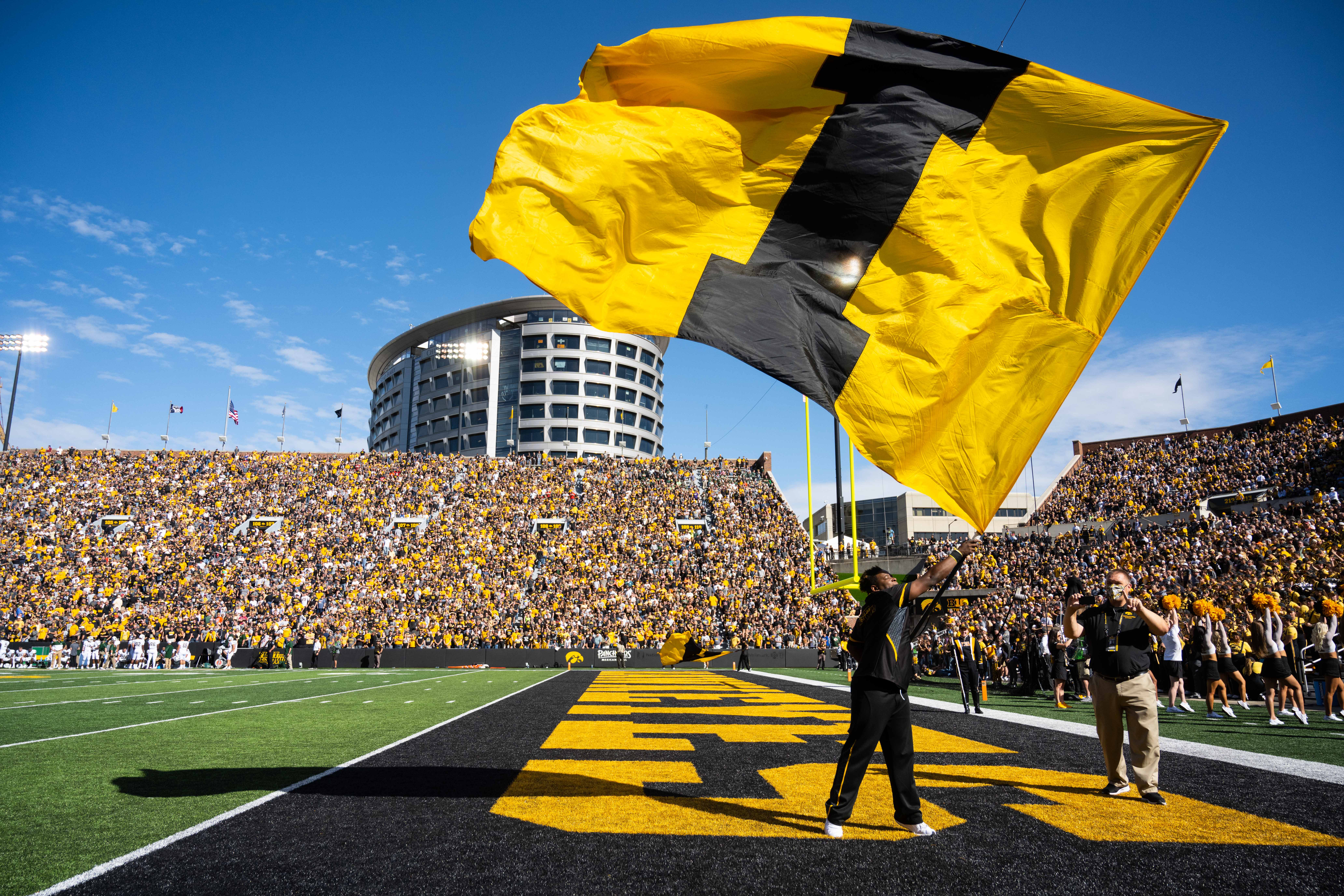 Iowa home game with the I flag waving in front of the crowd and Children's Hospital