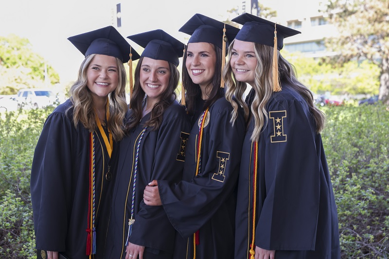 Four students in graduation attire