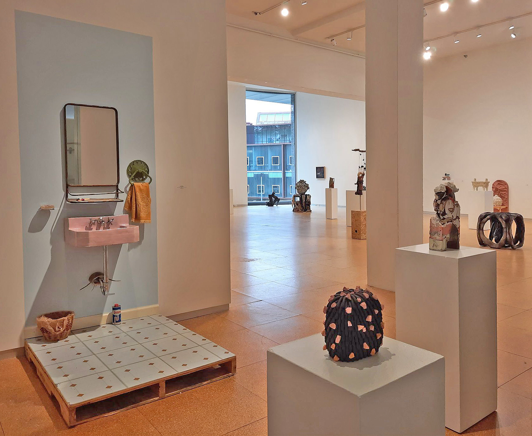 installation view of ceramics invitational show, cork floors, white walls, ceramics pieces from across the country