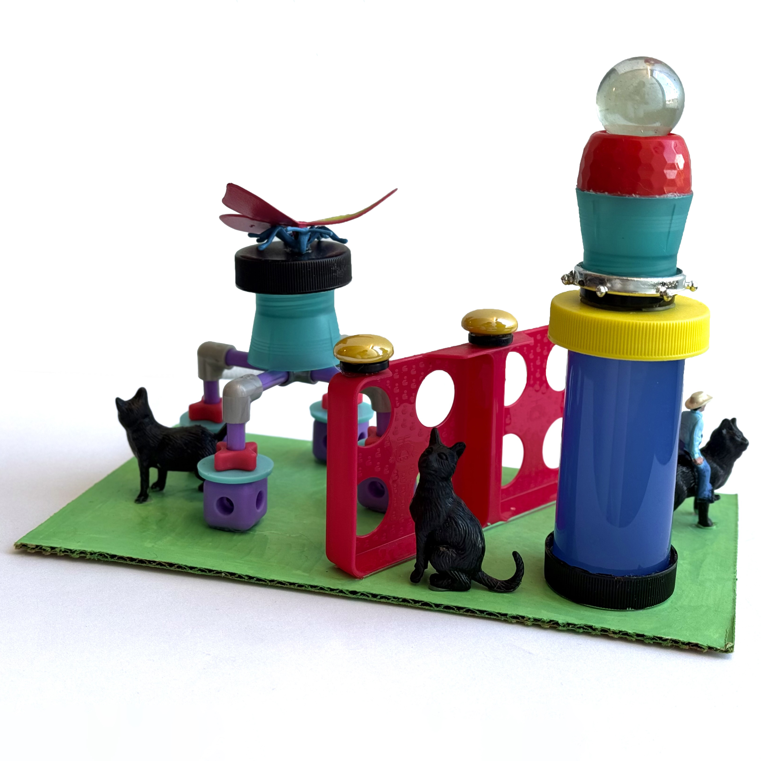 A colorful structure made of toy figurines, plastic shapes and marbles