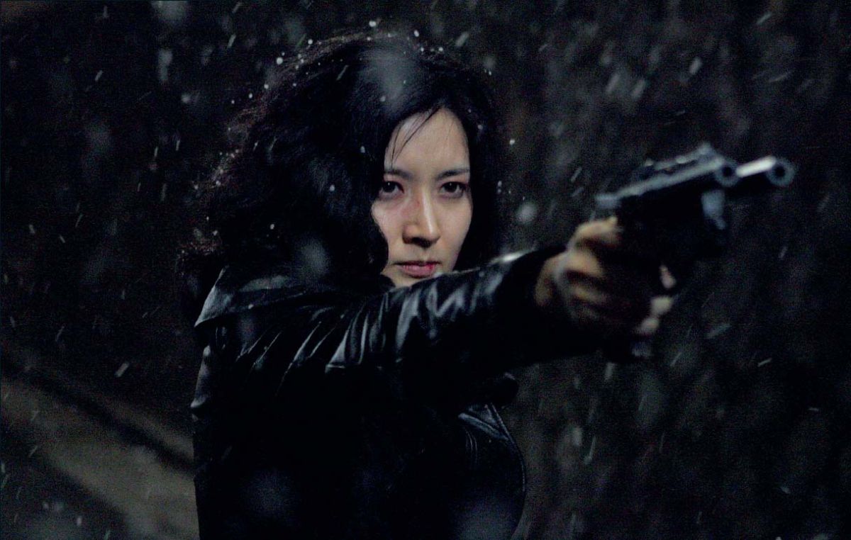 Lee Young-ae in darkness pointing a gun in a scene from Lady Vengeance.