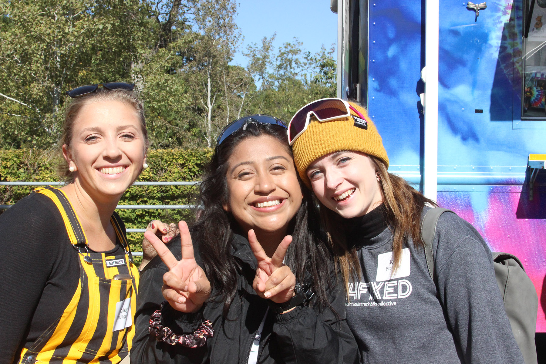Three smiling young women dressed in black and gold colors at Iowa's homecoming
