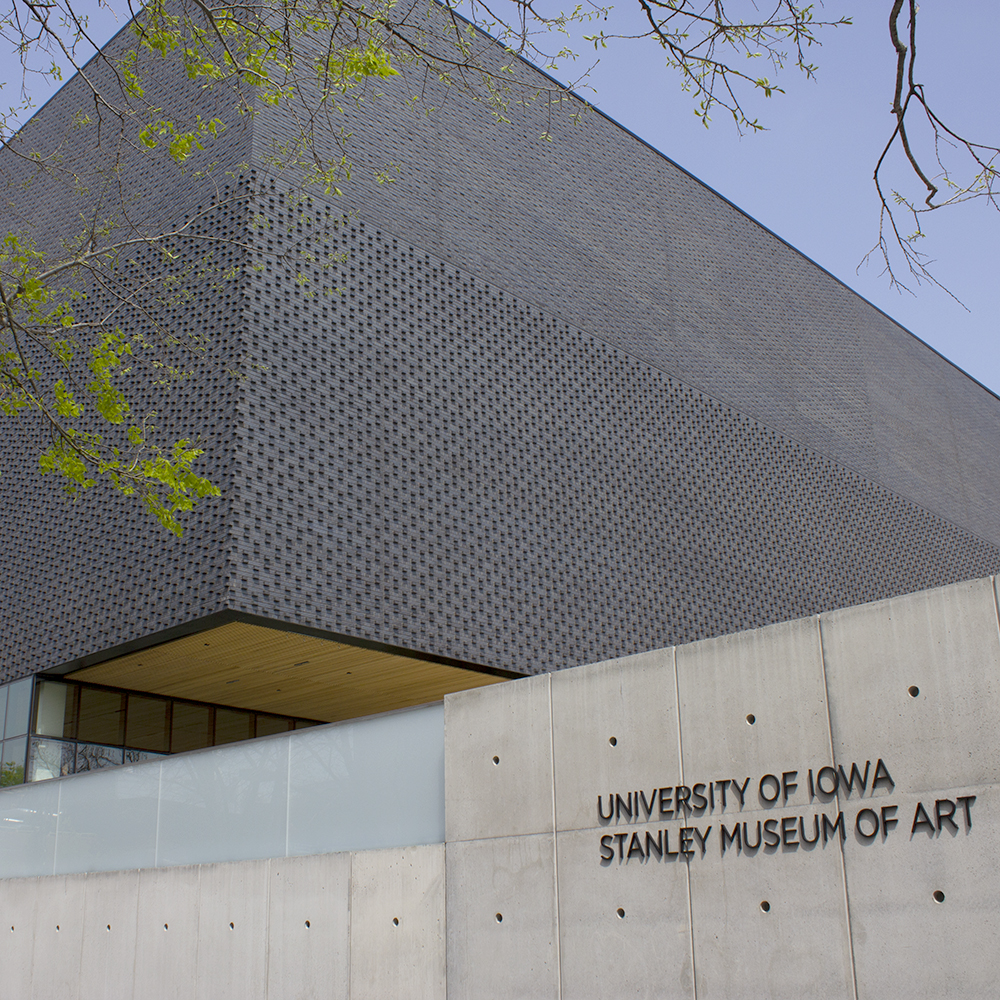 Exterior view of front corner of the University of Iowa Stanley Museum of Art, with the name visible on the foundation wall in foreground