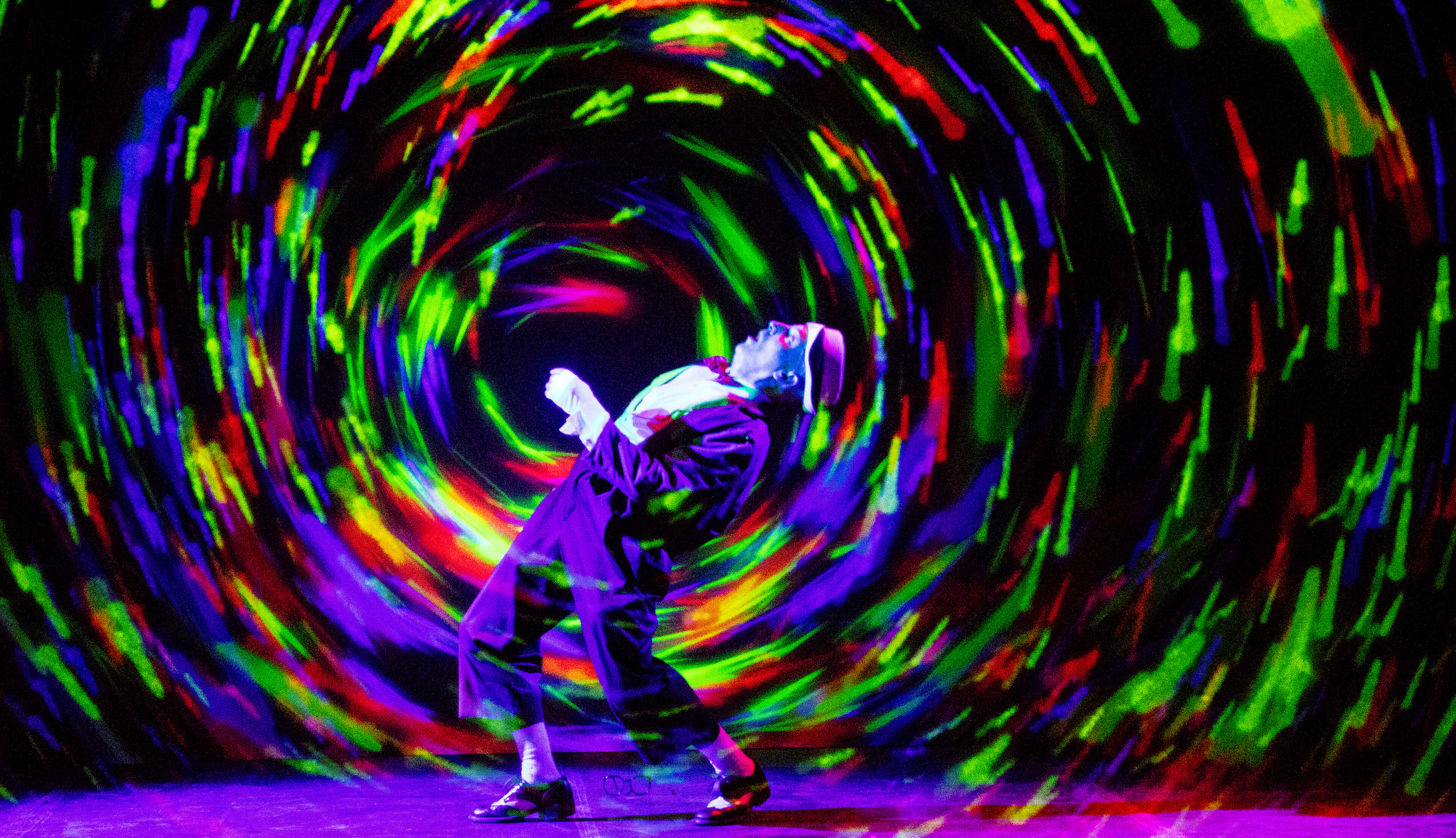 man standing amid swirl of digital colors