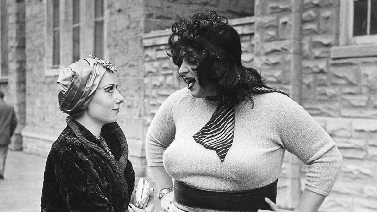 Divine and Mink Stole in campy dress talking on the street in a scene from Multiple Maniacs