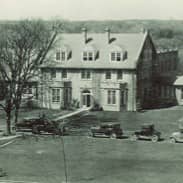 Early sepia tone photo of one of the UI Psychiatry buildings - two stores tall, early 1920s Tudor Revival architecture.