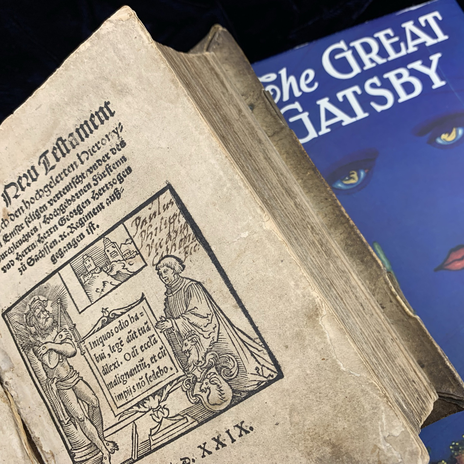 Two rare books are featured. One is a 1620s German New Testament and the other is a 1920s edition of The Great Gatsby.