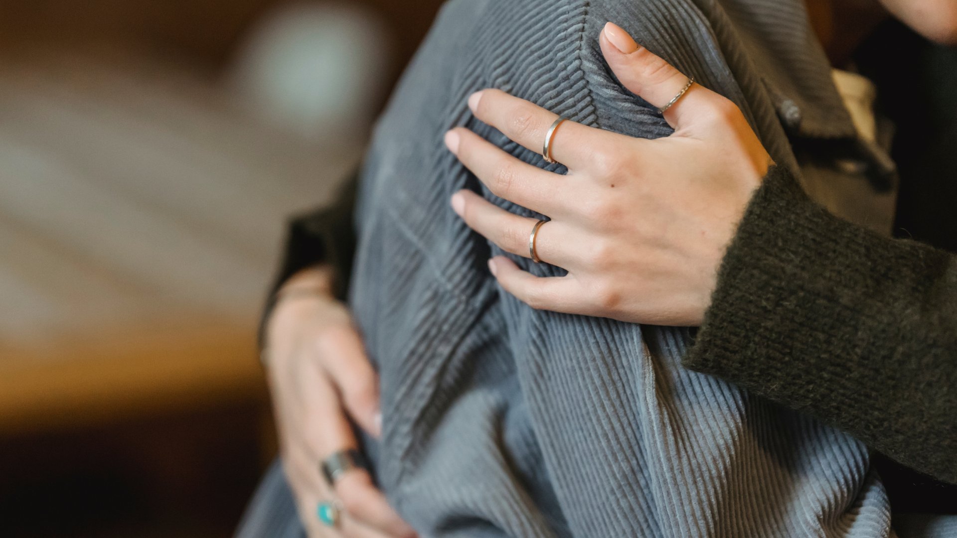 woman comforting another woman by holding her