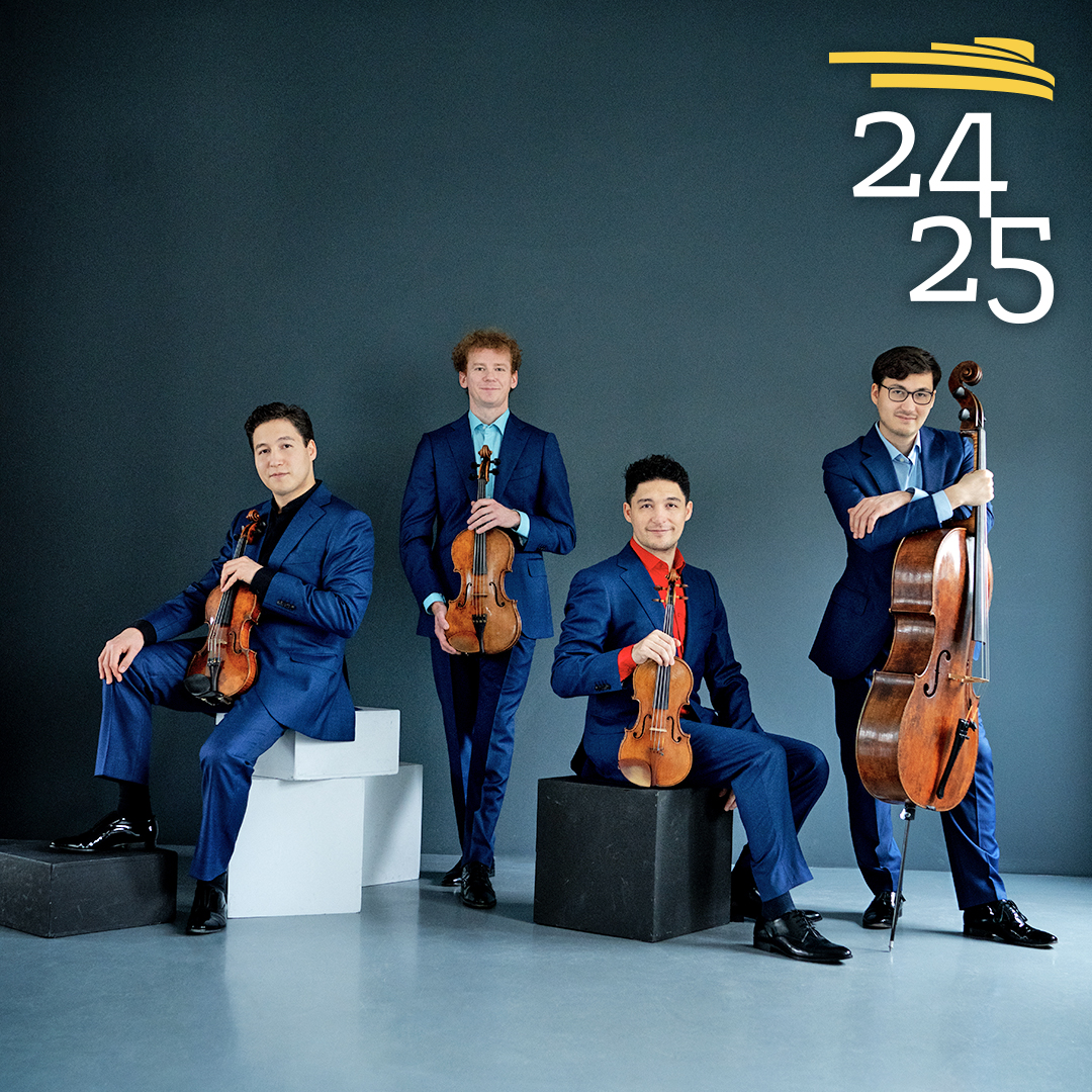 Schumann Quartet posed holding their instruments, all wearing a royal blue pant and jacket combo