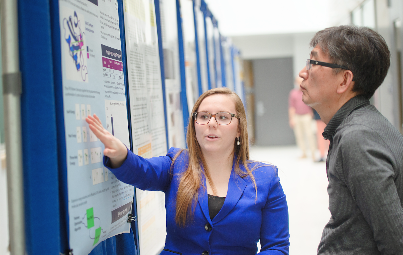 Student presents poster to professor