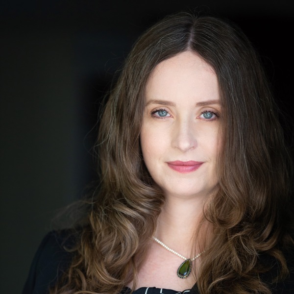 Young white woman with long brown hair stares at the camera