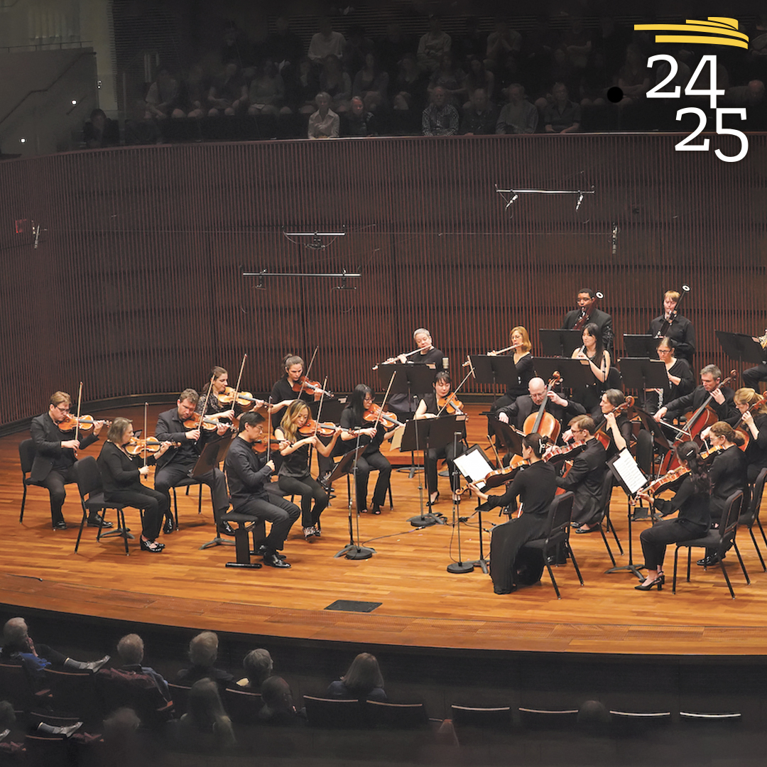 Saint Paul Chamber Orchestra on stage during performance with image of Dmitry Sinkovsky playing violin in lower left of the banner