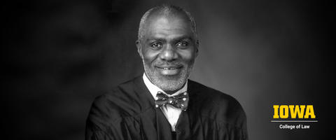 Black and white headshot of Alan Page center focus with block Iowa logo in lower right corner