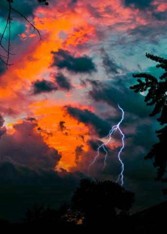 lightning in the sky during a blazing sunset