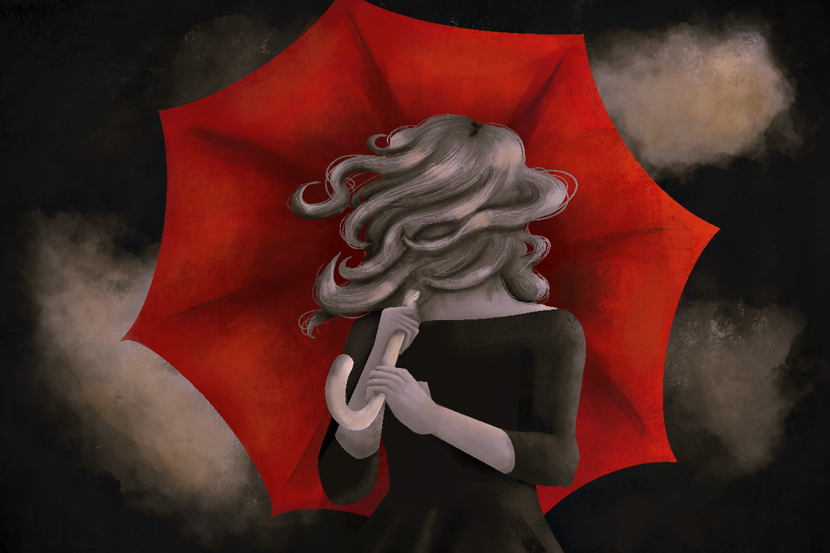 Woman with long windblown hair standing under a red umbrella.