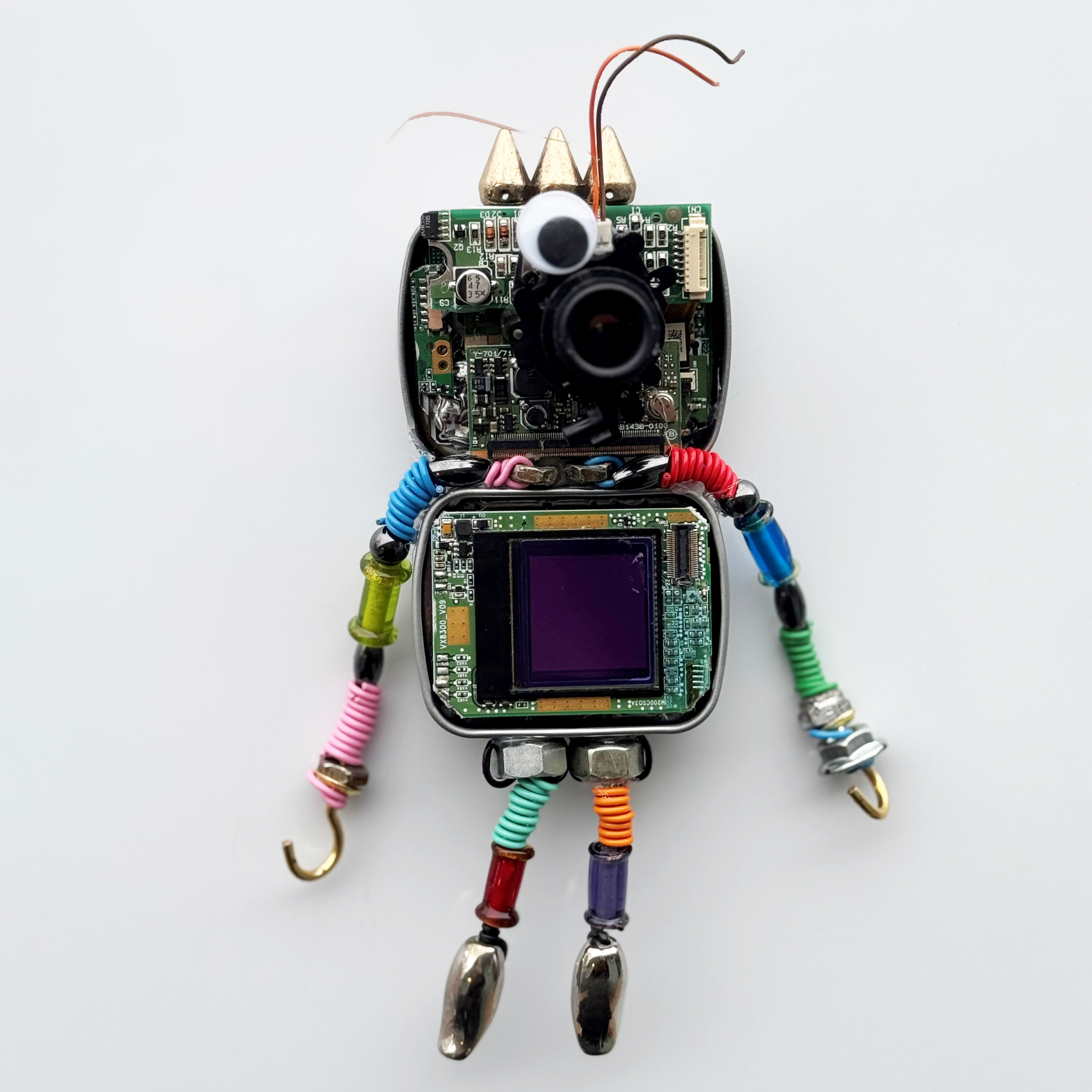 A robot figure crafted using tin boxes, bolts, and colorful wires.