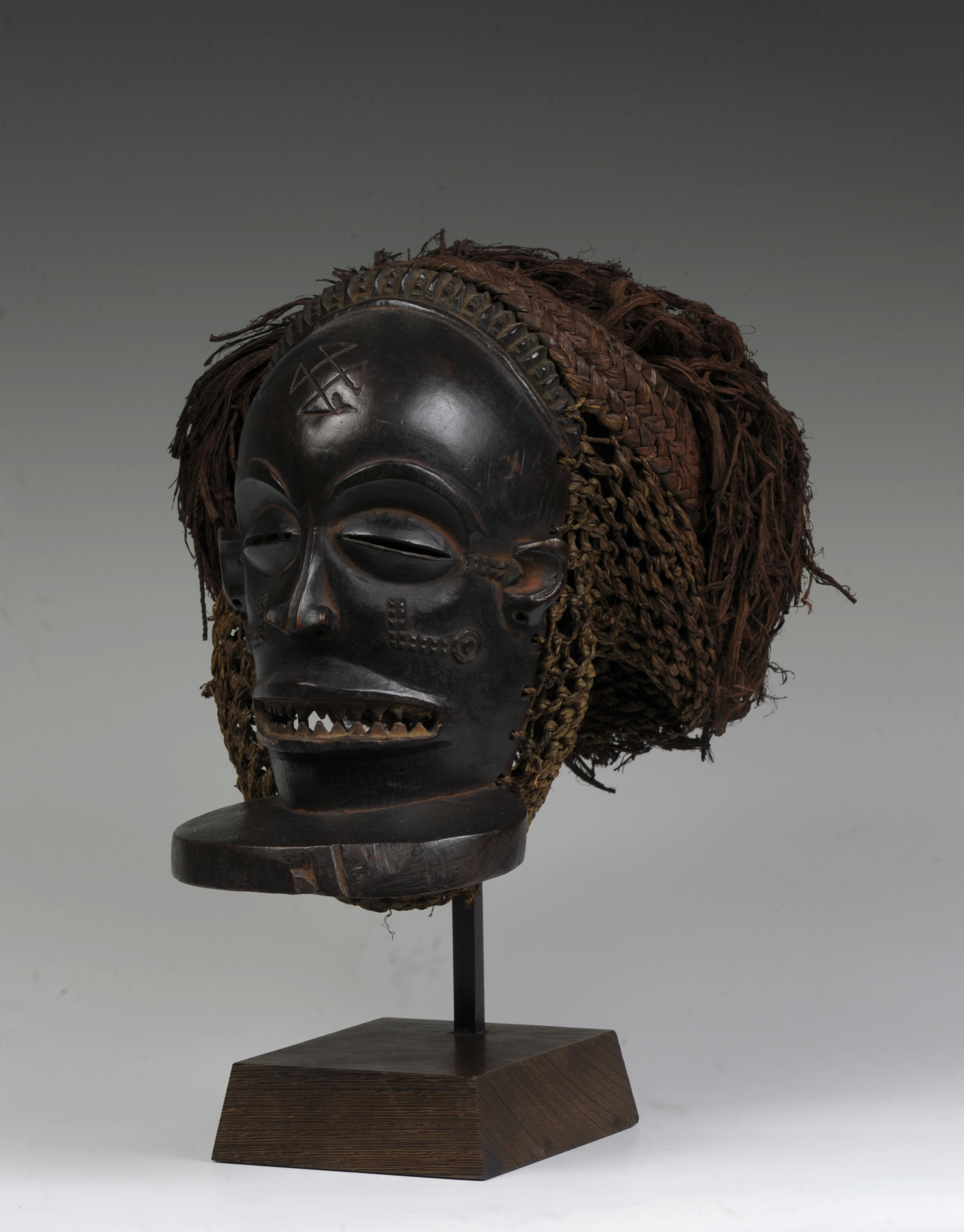 Chihongo (male face mask), Chokwe style. Early to mid-20th century. Wood, cotton, bark, raffia. 11 1/2  x 9  x 10 3/4 in. University of Iowa Stanley Museum of Art, The Stanley Collection of African Art, X1990.598